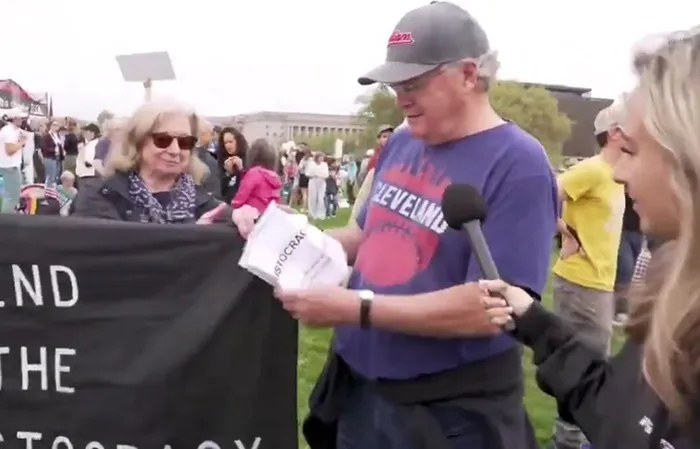 Protester doesn't know what he's doing, needs to read paper to remember