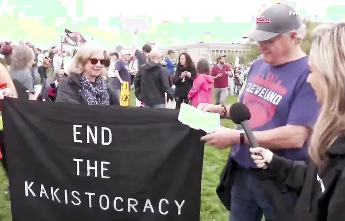 Protester doesn't know what he's doing, needs to read paper to remember