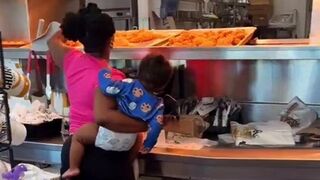 Woman goes behind counter to take chicken, uses baby as human meat shield