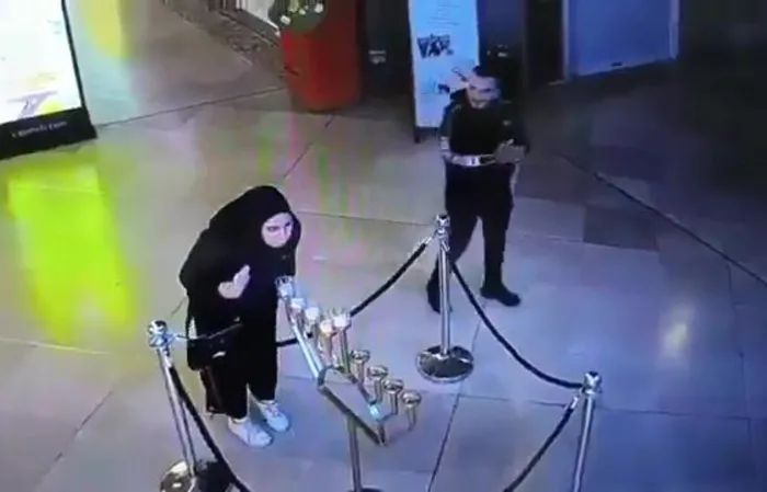 Muslim woman blows out menorah candles during Hannukah