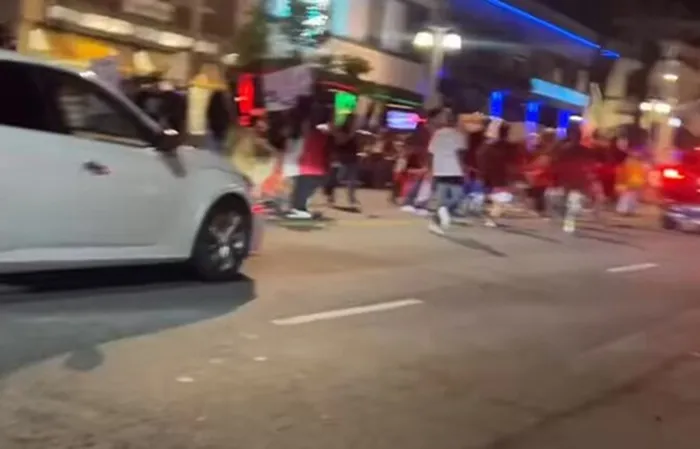 Rioters attack car, driver speeds up and hits someone while trying to escape