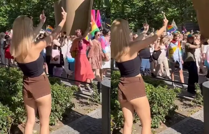 Woman shows one-handed gesture to protesters