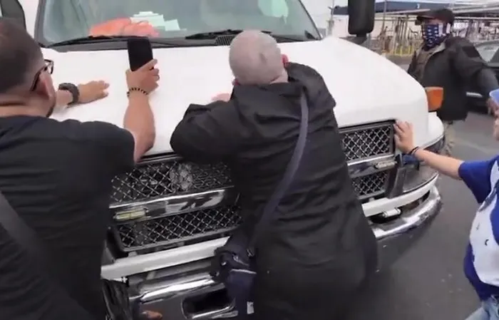 Protesters jump on ICE vehicle, clash with officers