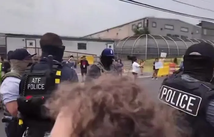 Protesters jump on ICE vehicle, clash with officers