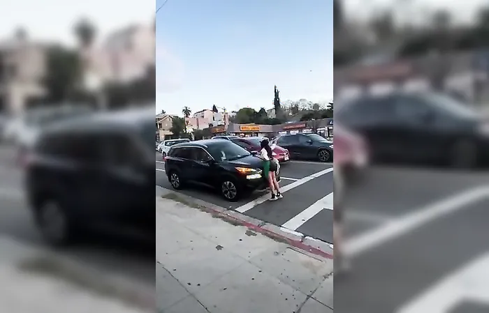 Group of women throw drinks at car in traffic